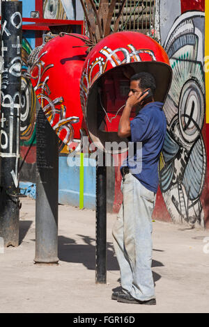 Kubanische Mann am Telefon mit dekorativen Kubanischen Kunstwerken rund um Telefone Callejon de Hamel, Havanna, Kuba, Karibik, Karibik, Zentral- und Lateinamerika Stockfoto