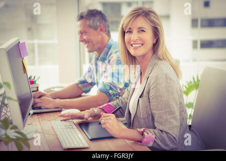 Lächelnd lässige Designer vor ihr Arbeitskollege Stockfoto