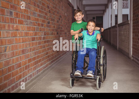 Student im Rollstuhl und Freund neben ihm lächelnd Stockfoto