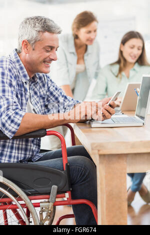Lässige Geschäftsmann im Rollstuhl mit smartphone Stockfoto