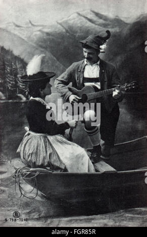 Kitsch / Souvenir, Mann in bayerischer Tracht, der für eine Frau etwas auf der Gitarre spielt, um 1910, Zusatz-Rechte-Clearenzen-nicht vorhanden Stockfoto