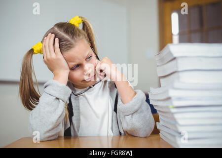 Traurig Schüler sitzt an ihrem Schreibtisch in einem Klassenzimmer Stockfoto