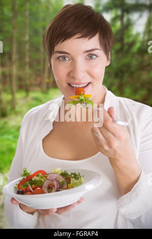 Zusammengesetztes Bild Portrait schöne schwangere Frau essen Salat Stockfoto