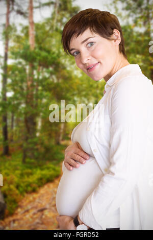 Zusammengesetztes Bild Porträt des Lächelns schwangere halten Bauch Stockfoto