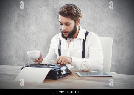 Zusammengesetztes Bild Hipster halten Kaffee arbeiten auf Schreibmaschine Stockfoto