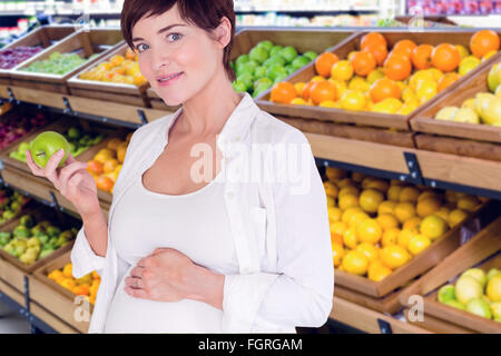 Zusammengesetztes Bild Porträt schwangere Frau mit grünem Apfel Stockfoto