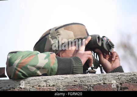 Srinagar, Kaschmir. 22. Februar 2016. Ein Soldat der indischen Armee nimmt Stellung in der Nähe von Gebäude, wo Kämpfer während einer Schießerei Sempora Pampore, etwa 15 km südlich von Srinagar, der Sommerhauptstadt des indischen Teil Kaschmirs, 22. Februar 2016 eingelocht wurden. Bildnachweis: Basit Zargar/Alamy Live-Nachrichten Stockfoto