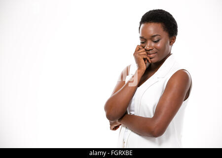 Ziemlich lächelnde afroamerikanischen jungen Frau stehen und denken über weißem Hintergrund Stockfoto