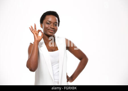 Fröhliche attraktive afrikanische amerikanische junge Frau zeigt ok Geste auf weißem Hintergrund Stockfoto