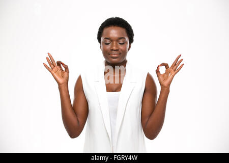 Friedliche attraktive afrikanische amerikanische junge Frau meditieren und ruhig zu halten, auf weißem Hintergrund Stockfoto