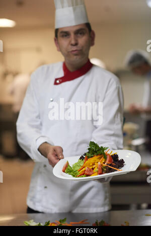 Koch in Hotelküche vorbereiten und dekorieren Essen Stockfoto