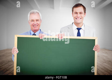 Zusammengesetztes Bild des Lächelns Handwerker mit leere Schild Stockfoto