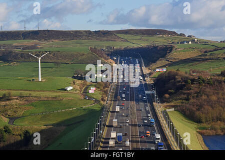 Schwerverkehr unterwegs die m62 vorbeifahrenden Windmühle in der Nähe von Moos moor Huddersfield Yorkshire uk Stockfoto