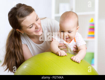 Mutter spielt mit Baby auf Fit Ball. Stockfoto