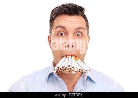 Ratlos junger Mann mit einem Bündel von Zigaretten in den Mund isoliert auf weißem Hintergrund Stockfoto