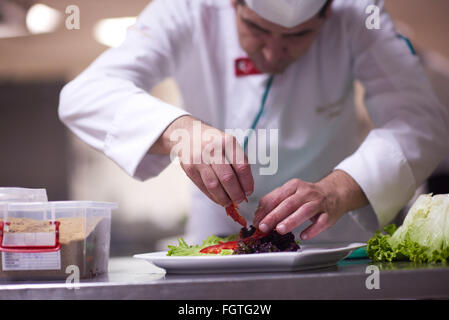 Koch in Hotelküche vorbereiten und dekorieren Essen Stockfoto