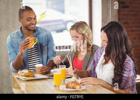 Geschäftsleute mit Frühstück im Büro Stockfoto