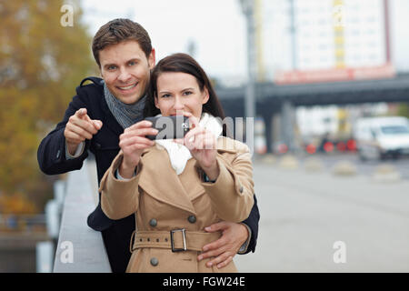 Brautpaar mit Kamera im Handy in einer Stadt Stockfoto