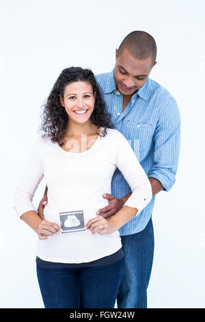 Glückliche Frau mit Ultraschalluntersuchung und Ehemann vor weißem Hintergrund Stockfoto