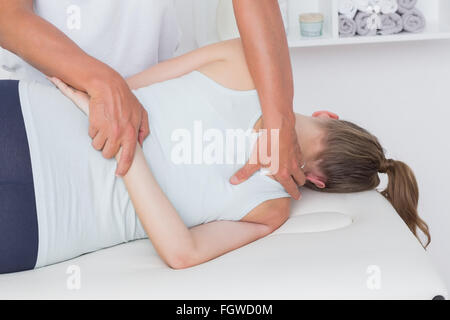 Arzt, die Dehnung einer Frau zurück Stockfoto