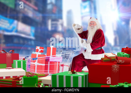 Zusammengesetztes Bild von Santa, die Geschenke aus dem Warenkorb zu liefern Stockfoto