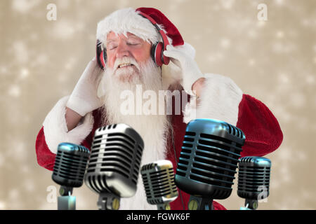 Zusammengesetztes Bild des Weihnachtsmannes genießt einige Musik Stockfoto