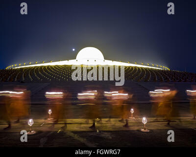 22. Februar 2016 - Khlong Luang, Pathum Thani, Thailand - buddhistische Mönche beteiligt die leichte Kerzenprozession um den Chedi während der Makha Bucha-Tag-Service im Wat Phra Dhammakaya.  Makha Bucha-Tag ist ein Feiertag in Kambodscha, Laos, Myanmar und Thailand. Viele Menschen gehen zum Tempel, um Verdienst ausgerichteten Tätigkeiten auf Makha Bucha-Tag, ausüben, welche vier wichtige Ereignisse im Buddhismus markiert: 1.250 Schüler kamen, den Buddha zu sehen, ohne beschworen wird, alle von ihnen waren Arhantas, erleuchtet sind, und alle waren vom Buddha selbst ordiniert. Der Buddha gab den Arhantas die Grundsätze der Stockfoto