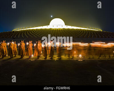 22. Februar 2016 - Khlong Luang, Pathum Thani, Thailand - buddhistische Mönche beteiligt die leichte Kerzenprozession um den Chedi während der Makha Bucha-Tag-Service im Wat Phra Dhammakaya.  Makha Bucha-Tag ist ein Feiertag in Kambodscha, Laos, Myanmar und Thailand. Viele Menschen gehen zum Tempel, um Verdienst ausgerichteten Tätigkeiten auf Makha Bucha-Tag, ausüben, welche vier wichtige Ereignisse im Buddhismus markiert: 1.250 Schüler kamen, den Buddha zu sehen, ohne beschworen wird, alle von ihnen waren Arhantas, erleuchtet sind, und alle waren vom Buddha selbst ordiniert. Der Buddha gab den Arhantas die Grundsätze der Stockfoto