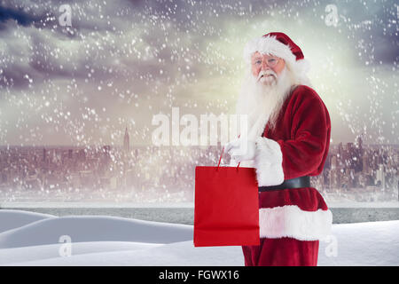 Zusammengesetztes Bild von Santa trägt rote Geschenktüte Stockfoto