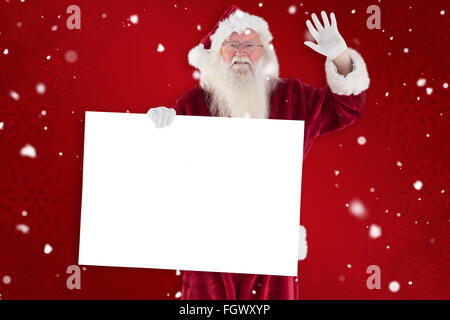 Zusammengesetztes Bild von Santa hält ein Schild und winkt Stockfoto