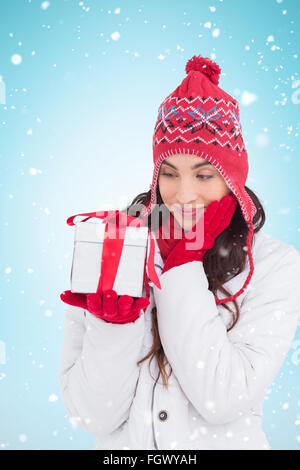 Zusammengesetztes Bild Inhalt Brünette im Winterkleidung mit Geschenk Stockfoto