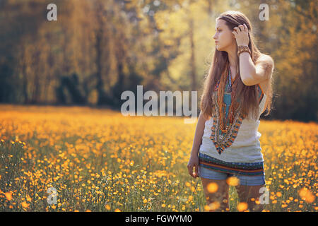 Wunderschöne Hippie-Frau in Blumenwiese. Sommerfarben Stockfoto