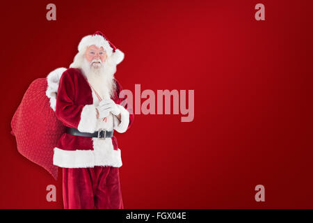 Zusammengesetztes Bild von Santa trägt seine rote Tasche Stockfoto