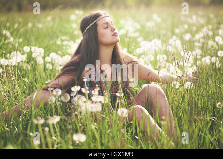 Wunderschöne Hippie-Frau Sonne Licht in blühenden Wiese genießen. Einklang mit der Natur Stockfoto