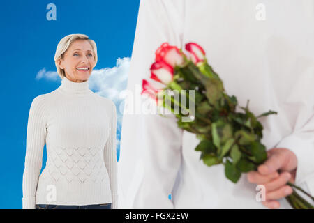 Zusammengesetztes Bild des Mannes versteckt Strauß Rosen aus älteren Frau Stockfoto