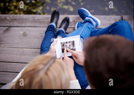 Glückliches Paar halten Ultraschallbild ihres Babys Stockfoto