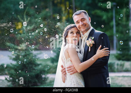glückliche Braut und Bräutigam und bläst Luftblasen im park Stockfoto
