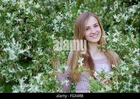 schöne glückliche Frau in blühenden Frühlingsgarten an einem warmen Tag Stockfoto