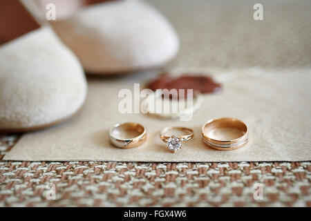 Zwei goldene Hochzeit Ringe und Schuhe der Braut auf Hintergrund Stockfoto