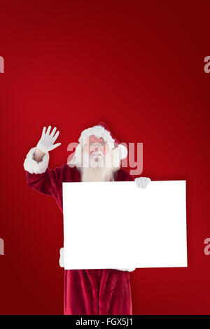 Zusammengesetztes Bild von Santa hält ein Schild und winkt Stockfoto