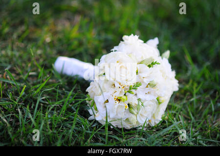 schöne Braut Hochzeit Bouquet liegen auf dem Rasen Stockfoto