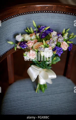 Rosa und lila Blumen im Brautstrauß Hochzeit auf Stuhl Stockfoto