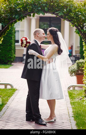 Bräutigam küssen seine Braut am Tag der Hochzeit in der Nähe von Bogen Stockfoto