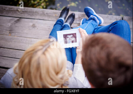 Glückliches Paar halten Ultraschallbild ihres Babys Stockfoto