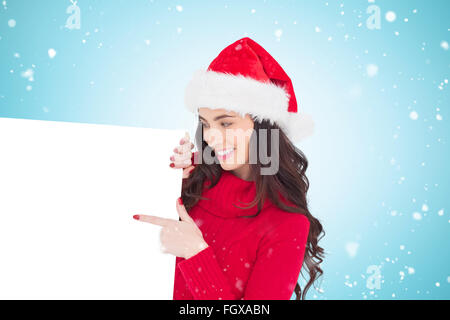 Zusammengesetztes Bild der Schönheit Brünette in Santa Hut zeigt weißes Plakat Stockfoto