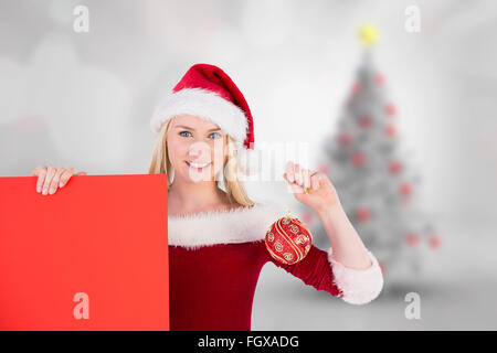Zusammengesetztes Bild der festliche süße blonde Holding Poster und Tand Stockfoto