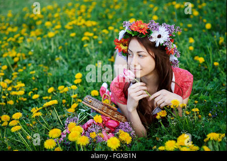 schöne Frau in einen Kranz auf dem Rasen auf einer Wiese liegend Stockfoto