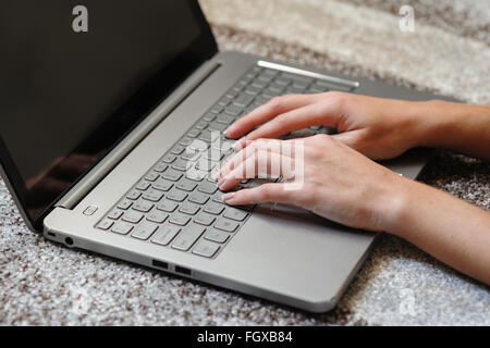 Frau Finger auf der Laptoptastatur im Büro Stockfoto