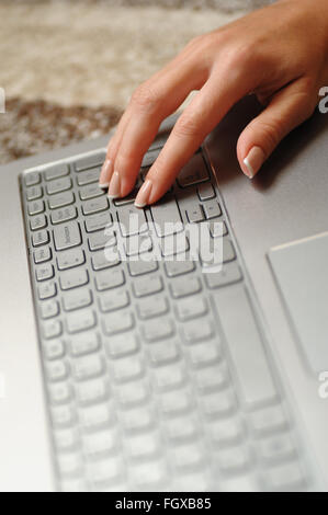 Frau Finger auf der Laptoptastatur im Büro Stockfoto