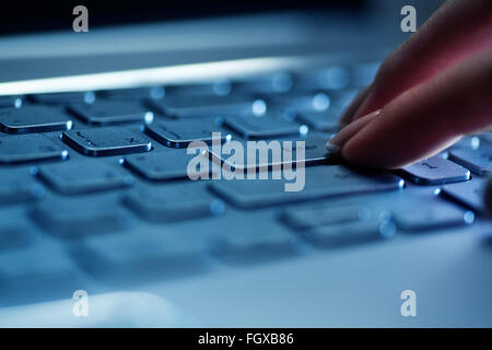 Frau Finger auf der Laptoptastatur im Büro Stockfoto